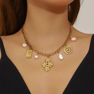 Gold-plated necklace with multi-element floral, spiral, and pearl pendants on a female model