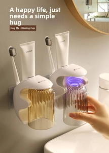 Wall-mounted magnetic toothbrush holder with amber and grey striped cups in bathroom