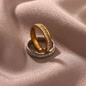 Detail of 18K gold and silver stainless steel rings with shimmering zircon inlay