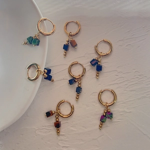 Macro view of French retro gold hoop earrings with colorful natural square stone pendants