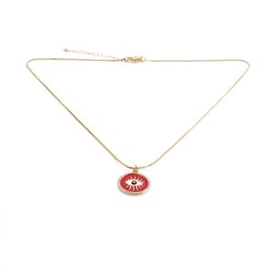 Close-up of golden necklace with red enamel evil eye pendant and sparkling crystals