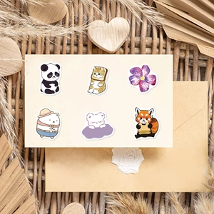 Detail showing cute animal stickers including pandas and cats on a rustic paper background
