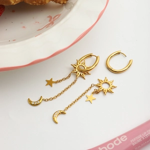Détail de boucles d'oreilles en acier inoxydable doré avec pendentifs lune et étoile