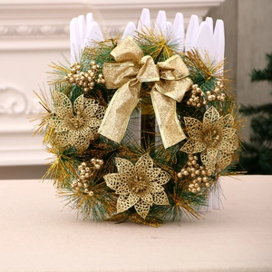Artificial Christmas wreath with gold poinsettias, glittery bows and green pine needles