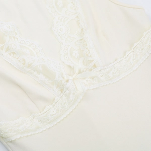Close-up of the delicate lace trim and satin bow detail on a cream V-neck vest top