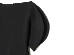 Detailed close-up of black fashion top featuring elegant ruffle puff sleeves and textured fabric