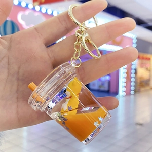 Detail of yellow oil-filled acrylic soda bottle keychain with a cute dog figure inside