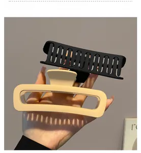 Detail of matte rectangular and wavy hair claws in coffee and black for thick hair