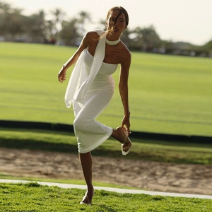 Elegant white strapless bodycon midi dress with matching neck scarf on outdoor lawn
