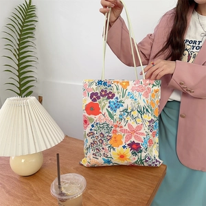 Détail du sac cabas en toile fleurie avec de fines bretelles dans une scène de vie