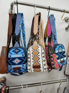 Detailed close-up of Bohemian canvas sling bags with ethnic geometric patterns and wide straps