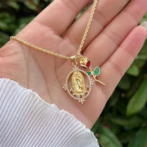 Detail of 18K gold-plated necklace with Virgin Mary and red enamel rose pendants