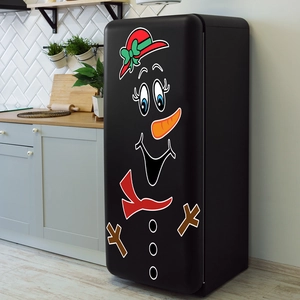 Detail of Christmas snowman magnetic stickers with red hat and carrot nose on a black fridge