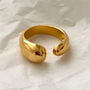 Detailed close-up of a 925 silver gold-plated water drop open ring on white paper