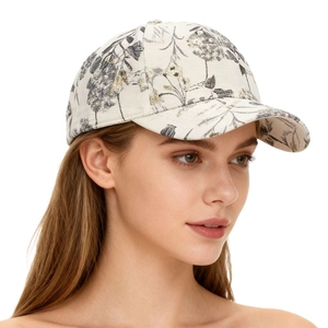Detailed close-up of floral gold-foil leaf patterns on a cream outdoor baseball cap