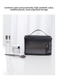 Detail of black mesh toiletry bag with zipper and handle for cosmetics storage