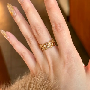 Close-up of gold plated hollow weave ring with sparkling cubic zirconia on a model's finger