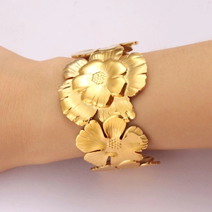 Statement gold floral bangle with overlapping petals in a high-fashion layered design
