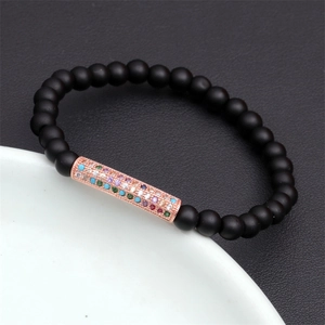 Detail of beaded bracelet with matte tiger eye stones and rose gold zircon tube charm