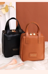 Detail of PU leather shell cosmetic bags with golden light travel logo and dual zippers