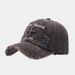Detail of distressed baseball cap with cross embroidery and frayed vintage brim texture