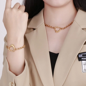 Set collana e bracciale dorati con ciondolo a cuore indossati da una modella
