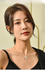 Detailed view of golden clover necklace with mother of pearl and small diamond on model