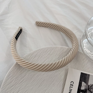 Macro detail of beige corduroy headband showing ribbed texture and handmade label