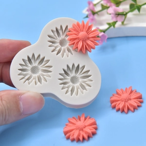 Handheld 3-cavity daisy silicone mold for DIY soap and candles on blue background