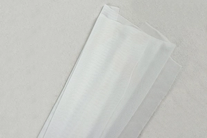 Detail view of the white mesh fabric texture with a breathable honeycomb knit structure