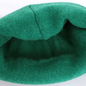 Detailed macro view of internal stitching and soft green knit texture of the beanie