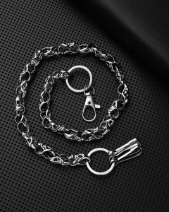 Detail of metal skull chain with lobster clasp and keyrings on black background