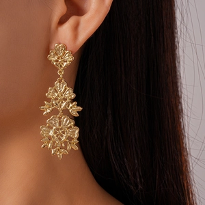 Dettagli di orecchini a fiore traforati vintage con design a petali placcati in oro a tre strati