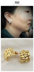 Detail of woven texture gold and silver earrings showing intricate braided metal design