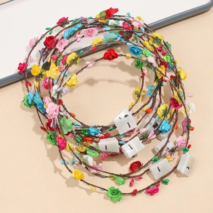 Close-up of colorful floral LED headbands with battery packs and artificial flowers