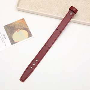 Detail view of a vibrant red leather wrist strap with silver metal buckle and hole patterns