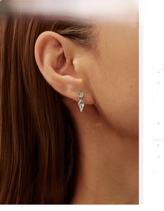 Close-up of S925 sterling silver kite-shaped crystal earrings worn on a model ear