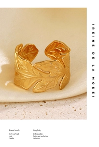 Detailed macro view of gold leaf ring with matte finish texture on silk fabric