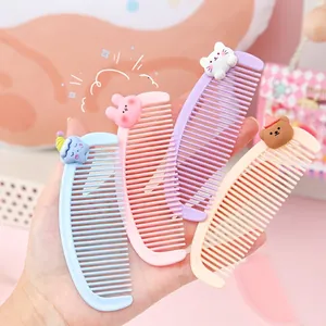 Set of four cute cartoon resin hair combs for kids in pastel colors held in hand