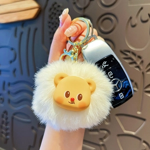 Cute white plush cream bear keychain with golden metal ring held by hand