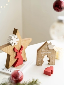 Close-up of wooden Christmas star and house ornaments with reindeer and snowflake details
