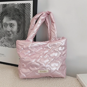 Dettaglio della borsa rosa trapuntata con cuciture a cuore ed etichetta del marchio