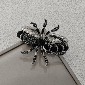 Close-up of gothic spider bracelet featuring black gemstone and beaded metallic details