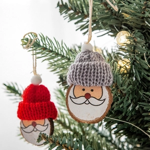 Mini-Weihnachtsmann-Anhänger aus Holz mit Strickmützen an einem Weihnachtsbaumzweig