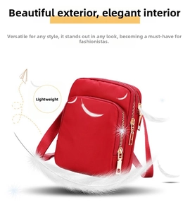 Detail of red nylon crossbody phone bag with multi-zipper and lightweight feather decor