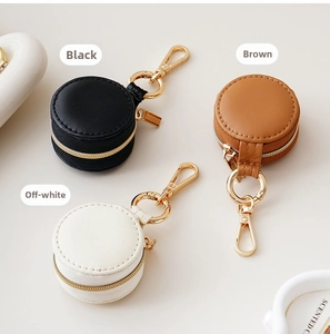 Detailed close-up of mini round faux leather jewelry cases in black, brown and cream colors