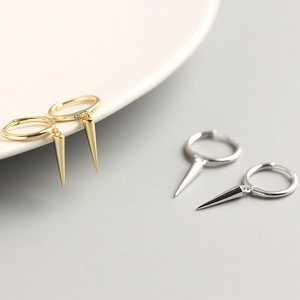 Detailed view of gold and silver minimalist cone pendant hoop earrings in polished metal