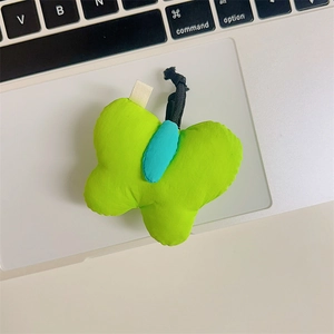 Macro detail of plush butterfly phone holder with green and blue fabric textures