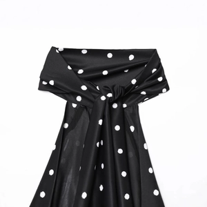 Retro black and white polka dot sleeveless top with silky texture and chic knot detail