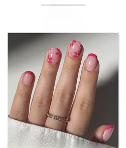 Close-up of short square press-on nails with red French tips and floral nail art
